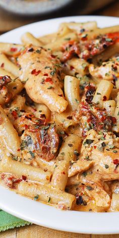 a white plate topped with pasta covered in sauce