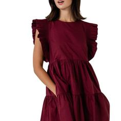 Duchy is a sleeveless babydoll style dress elevated by pleated ruffles at the shoulders, a classically designed tier skirting and hidden side seam pockets. In an elegant shade of rich burgundy, this cotton dress design is sophistication and forever youthful style blended together creating a timeless classic dress. Sleeveless babydoll style dress Ruffle detailing at sleeves Tier Skirting Side seam pockets Fully lined Slips on over the head with invisible zipper closure at back Self: 100% Cotton; Burgundy Dress Cotton Poplin, Maroon Dress Casual, Cotton Dress Design, Tiered Ruffle Mini Dress, Babydoll Style Dress, Snake Dress, Mixed Media Dress, Youthful Style, Maroon Dress