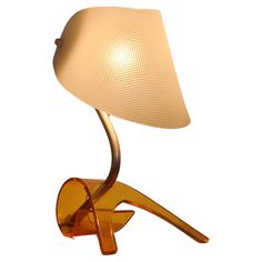 a lamp that is sitting on top of a wooden stand with a glass shade over it