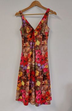 "Fabulous floral print mid-length sleeveless summer dress, circa late 1960s/early 1970s. Fitted style to bust with strappy V-neckline, and full skirt.  The perfect dress for a summer celebration or evening out!  Material: Polyester Condition: Excellent vintage condition - no damage or obvious signs of wear Recommended care: Machine wash Sizing: Label states UK Size 14 - would recommend current UK Size 10/12. Please see exact measurements below. Measurements (item laid flat): - Length (straps to hem) 106cms/41.75\" - Bust (width, doubled) 70cms/27.5\" - Waist (width, doubled) 80cms/31.5\" All items are clean and ready to wear. Want any further details, images or measurements? Feel free to get in touch if you'd like any further information about this item. RETURNS If an item doesn't quite fi