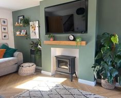 a living room filled with furniture and a flat screen tv mounted on the wall above a fire place