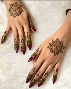 two hands with hendi designs on them, one is green and the other is red