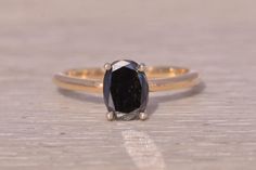 This stunning piece, known as The Midnight Eclipse, features a captivating 1.00 carat oval brilliant cut natural black diamond in a white gold head. The ring is crafted in 14 karat yellow gold and is currently a finger size 7 yet can be adjusted to any finger size for an additional charge upon request, ensuring a perfect fit. Love this piece, but don't have the money to spend right now? We offer FREE layaway on every item in our shop. With just 20% down, take one full year (interest-free) to pay off your new jewelry! There are no hidden fees or charges, ever. For more information on our layaway policy, please contact us. Each piece has been hand-selected and meticulously identified and graded by a Graduate Gemologist who has been awarded a degree by the Gemological Institute of America (GI Black Diamond Ring, The Midnight, Rings Statement, Black Diamond, Statement Rings, Diamond Ring, Jewelry Watches, Jewelry Rings, Perfect Fit