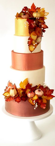 a three tiered cake decorated with fall leaves