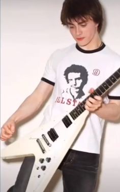 a young man is holding an electric guitar