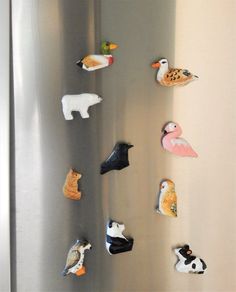 there are many different animal magnets on the refrigerator