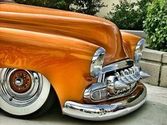 an orange classic car parked on the street