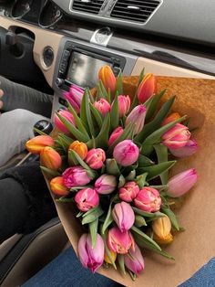 a bouquet of tulips sitting in the passenger seat of a car