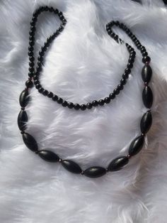 ❀ About ❀  Black Obsidian necklace (Vintage)  Gemstone : Obsidian Length: 29 inches (74cm) (Opera length) Weight: 59g This necklace is made with polished obsidian gemstone. The necklace is stringed with 6mm round beads and oval beads of 10mm at it's thickest point, is is opera length with a length of 29''. This vintage necklace is a perfect gift for that special someone. ❀ Will my jewelry look the same as the photo? ❀  All pictures are taken of actual products in natural light. Monitor settings Black Spiritual Double Strand Jewelry, Black Double Strand Bohemian Jewelry, Bohemian Long Necklace With Black Round Beads, Traditional Long Black Necklace, Black Double Strand Bohemian Necklace, Black Bohemian Double Strand Necklace, Vintage Black Beaded Necklace With Gemstone Beads, Vintage Black Gemstone Beads Necklace, Vintage Black Jewelry With Natural Stones