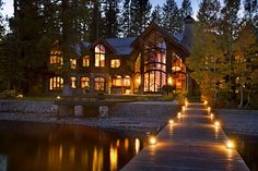 a house that is lit up at night with lights on the walkway leading to it