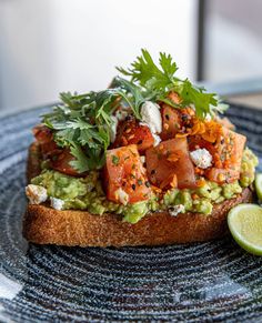 a piece of bread with guacamole, tomatoes and other toppings on it