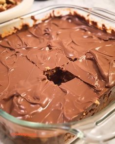 a chocolate dessert in a glass dish with one slice cut out and the other half eaten