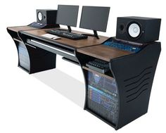 a computer desk with two monitors and speakers