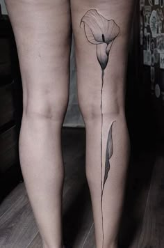 a woman's leg with a flower tattoo on it and the bottom part of her legs