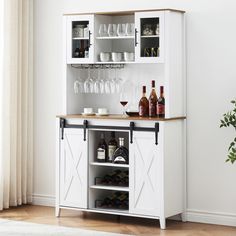 a white cabinet with wine glasses and bottles