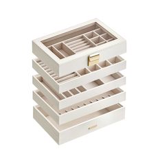 three white drawers stacked on top of each other with gold handles and compartments in them