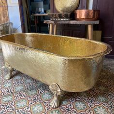 a gold bath tub sitting on top of a tiled floor