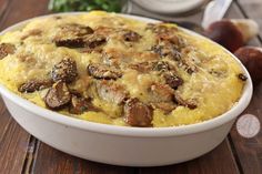 a casserole dish with mushrooms in it on a wooden table