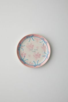 a pink and blue plate sitting on top of a white table next to a wall