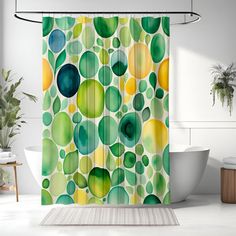 a shower curtain with green and yellow circles on it in a white bath room next to a tub