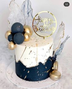 a white and blue cake with gold decorations