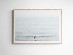 some birds are swimming in the ocean on a foggy day, framed in wood