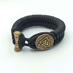 Follow Odin with Valknut paracord bracelet Valknut is symbol of weaving of nine worlds in Norse Mythology. This is custom hand woven bracelet made from paracord 550 (strong rope). The mens wristband with handmade beads made from Italian bronze solid. This bracelet is perfect gift option for Norse, Nordic or Viking style jewelry lovers, it can be used for men or women.. Description of Valknut bracelet: Material: Italian bronze solid (88 % Copper, 12% Tin) and Paracord 550 The bracelet is made for Durable Black Paracord Bracelets, Handmade Black Braided Bracelets For Outdoor, Durable Paracord Braided Bracelet For Outdoor, Handmade Black Paracord Braided Bracelet, Viking Symbol, Paracord Armband, Bracelet Viking, Viking Symbols, Viking Style