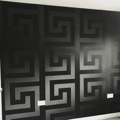 a black and white photo of a wall with an artistic design on it's side