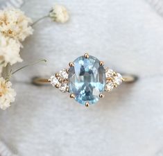 an oval cut blue topaz ring with three diamonds on the band and side stones