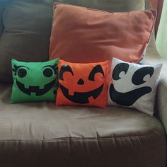 three halloween pillows sitting on top of a couch