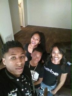 a group of young people standing next to each other in a living room smiling at the camera