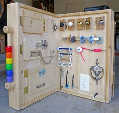 an open wooden box with lots of different items in it and some keys on the door