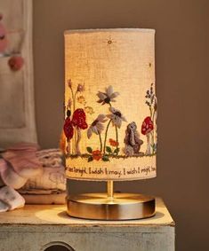 a lamp that is sitting on top of a wooden table next to a stuffed animal