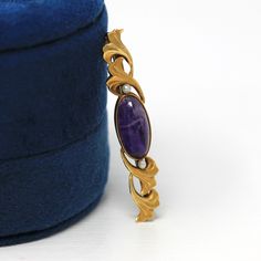 Gorgeous antique circa 1910s Art Nouveau era 14k yellow gold genuine amethyst brooch! This stunning statement piece has a flowing nature inspired setting, that is accented with two seed pearls and a genuine cabochon cut 3.68 carat amethyst gemstone. The genuine gem has beautiful eye catching inclusions, and the piece secures with a pin backing. A stylish bar pin fashion accessory from the Art Nouveau era! *Sale - price reduced from $310 USD to $235 USD.  ERA - Circa 1910s - Art Nouveau  METAL / 1910s Art, Amethyst Brooch, Pin Fashion, Accessory Jewelry, Beautiful Eye, Logo Gifts, Antique Brooches, Amethyst Gem, Seed Pearl