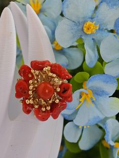 Maxi ring with flower handmade with gold-plated brass base, decorated with natural Mediterranean red coral and central pearl in imitation red coral paste, 2.5 cm diameter. Adjustable width Unique Red Flower-shaped Jewelry, Unique Red Flower Jewelry, Unique Red Flower Shaped Jewelry, Elegant Handmade Red Flower Ring, Coral Flower, Flower Handmade, Coral Flowers, Flower Ring, Red Coral