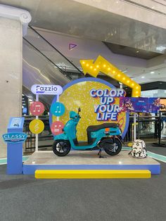 a scooter is parked in front of a sign that says color your life