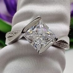 a white gold ring with a princess cut diamond