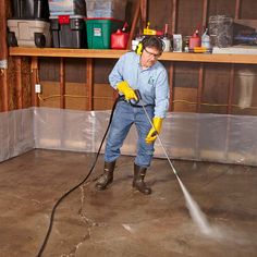 a man is using a pressure washer to clean the floor in his garage or workshop