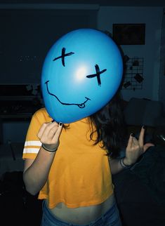 a woman wearing a smiley face balloon over her head