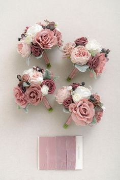 wedding bouquets with pink and white flowers are arranged next to a piece of paper