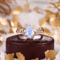 a close up of a ring on top of a wooden box with snow around it