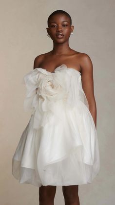 a woman wearing a white dress with flowers on it