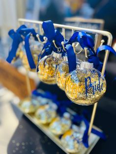 some blue and yellow ornaments are hanging from a rack on a table with other decorations