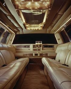 the inside of a limo with leather seats and champagne glasses in it's center console