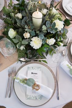 the table is set with white and green flowers