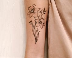 a black and white photo of a flower tattoo on the left arm, with flowers in it