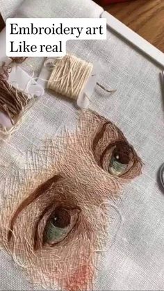 an embroidery art project with scissors and thread on the table next to it is a drawing of a woman's face