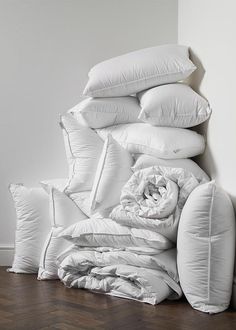 a pile of pillows sitting on top of a wooden floor