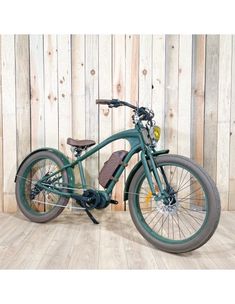 a green bicycle is parked in front of a wooden wall with planks on it