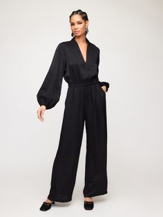 Introducing the Skyler Jumpsuit, made from shimmer material for a touch of glamour. With its relaxed fit and elastic waist, this jumpsuit is versatile and comfortable for a night out or formal occasion. Pair it with your favorite heels to complete the look. Size down to achieve a fitted look Shimmer Woven: 82% Viscose 18% Nylon Made in the USA of imported fabric Hand Wash Cold. Hang To Dry Or Dry Clean. Top length: 16 inches (size S) Long blouson sleeves V-neck Invisible back zipper closure Side Chic V-neck Relaxed Fit Jumpsuits And Rompers, Chic Evening Jumpsuits And Rompers For Fall, Sleek Pantsuit For Night Out In Spring, Chic Black Jumpsuits With Elastic Waistband, Sleek Evening Jumpsuits And Rompers For Fall, Elegant Wide Leg Jumpsuits And Rompers For Fall, Elegant Jumpsuits And Rompers For Evening In Fall, Summer Evening Long Sleeve Pantsuit, Elegant Wide Leg Jumpsuits For Fall